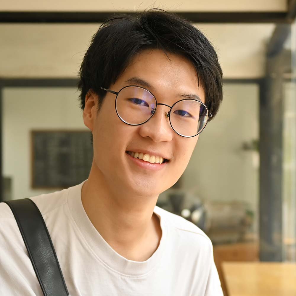 asian male university student in glasses holding b 5TFS3Y8